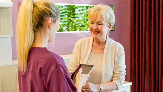 Komfortstation Bergmannsglück: Eine Krankenschwester notiert mit einem Tablet-PC die Informationen einer Patientin.